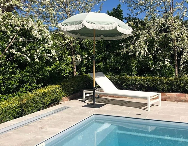 Lounger under Umbrella by a Pool